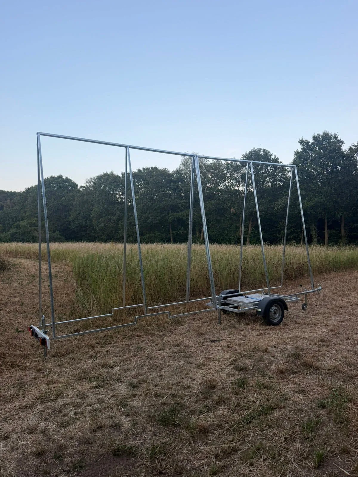 Reclameaanhangwagen met opgebouwd frame in een weiland, breed aanzicht